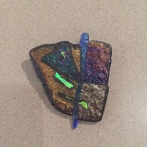 Ceramic brooch with iridescent glazes.